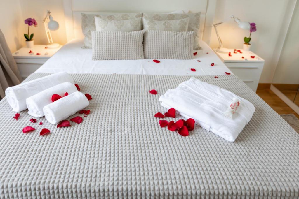White towels and rose petals on a beautifully prepared bed